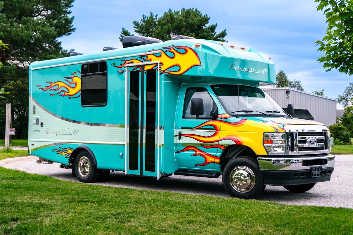 Classic teal Wag'n Tails cutaway mobile grooming van with custom Hot Rod flames