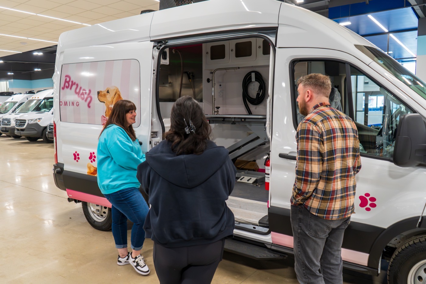 Owners touring an open Wag'n Tails mobile salon during pickup day