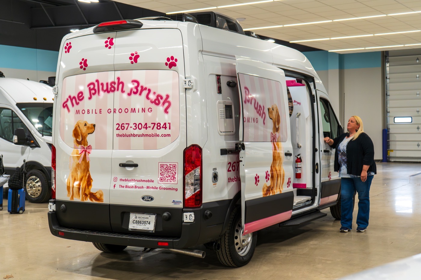 Wag'n Tails owner celebrating pickup with their custom-wrapped mobile grooming van