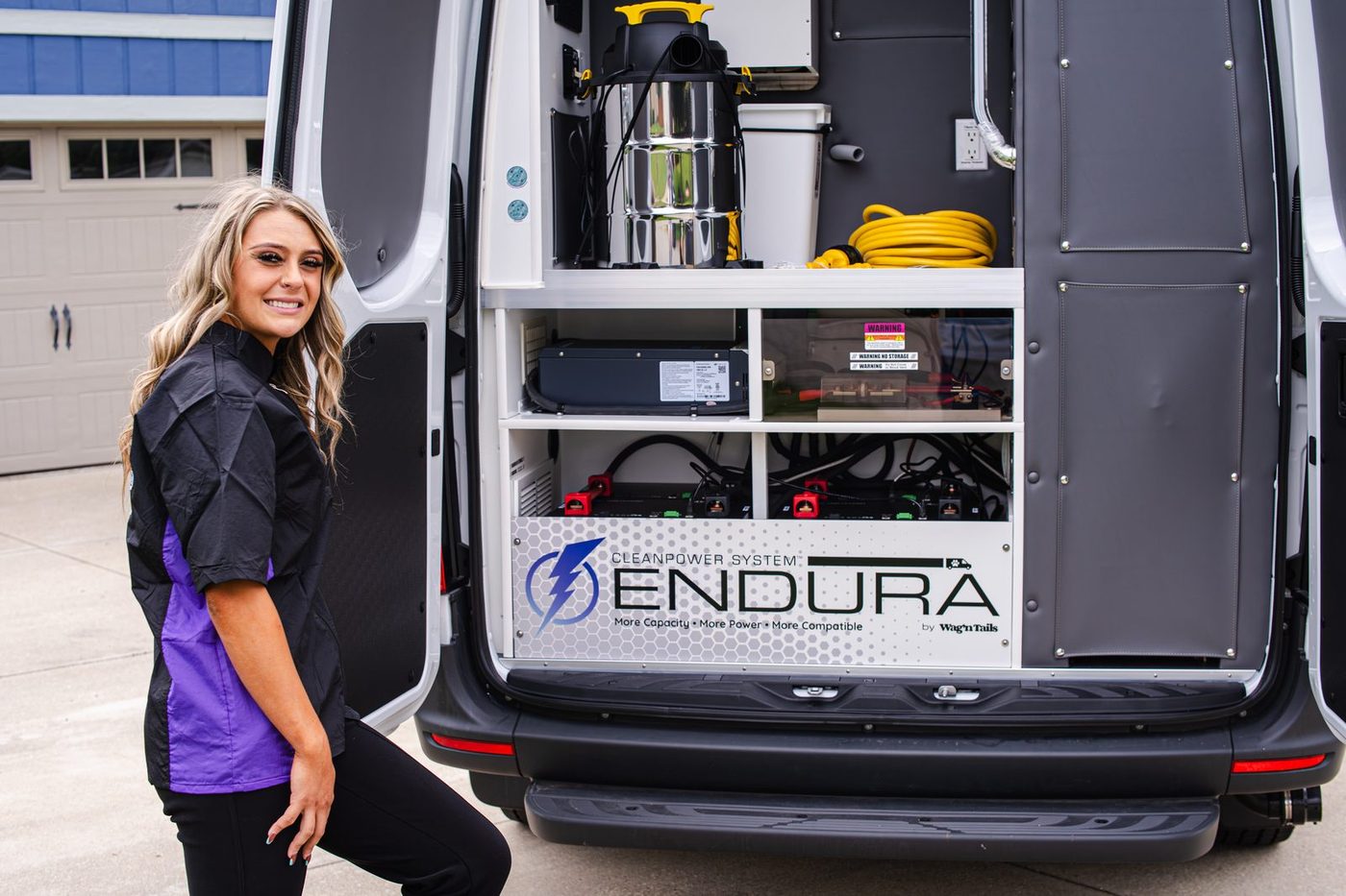 Mobile groomer beside an open Wag'n Tails van showing the CleanPower System Endura rear power bay