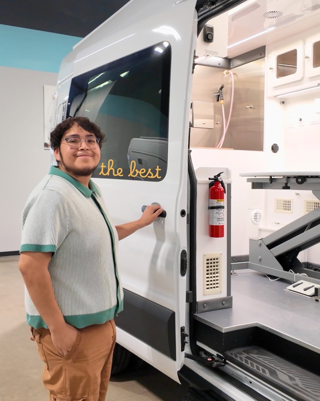 Wag'n Tails teammate with an open mobile grooming van on the shop floor