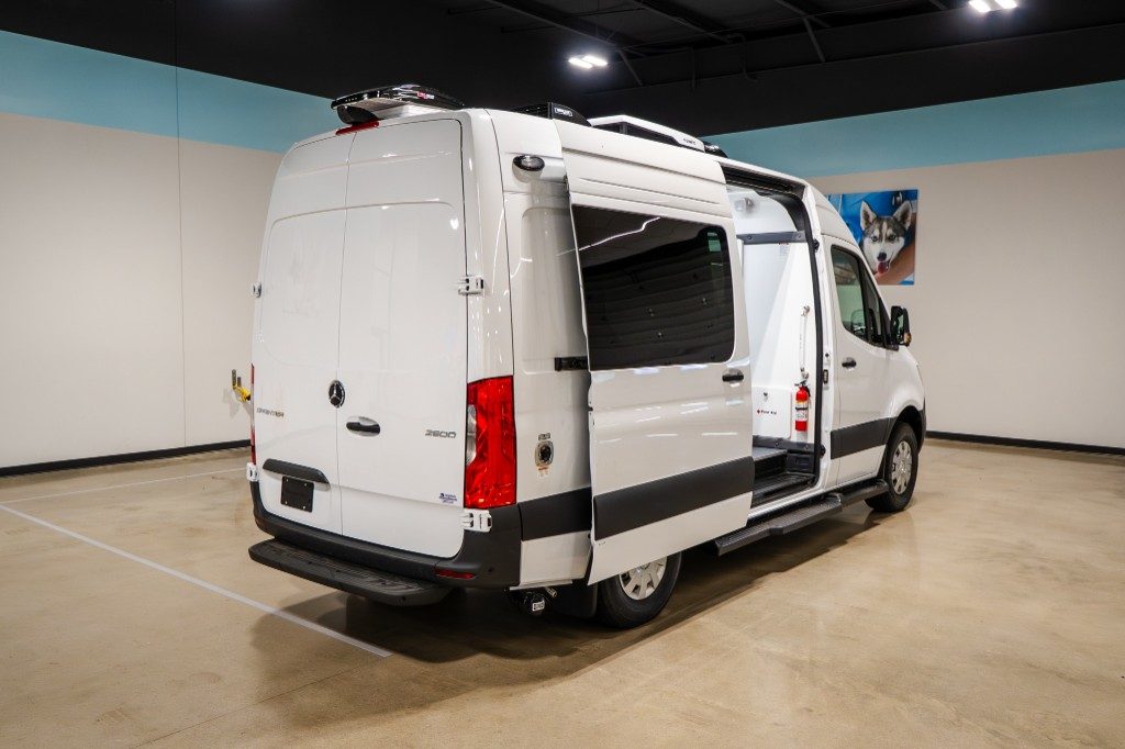 Quantum Groom Sprinter rear three-quarter view with sliding door open and simplified exterior utility area