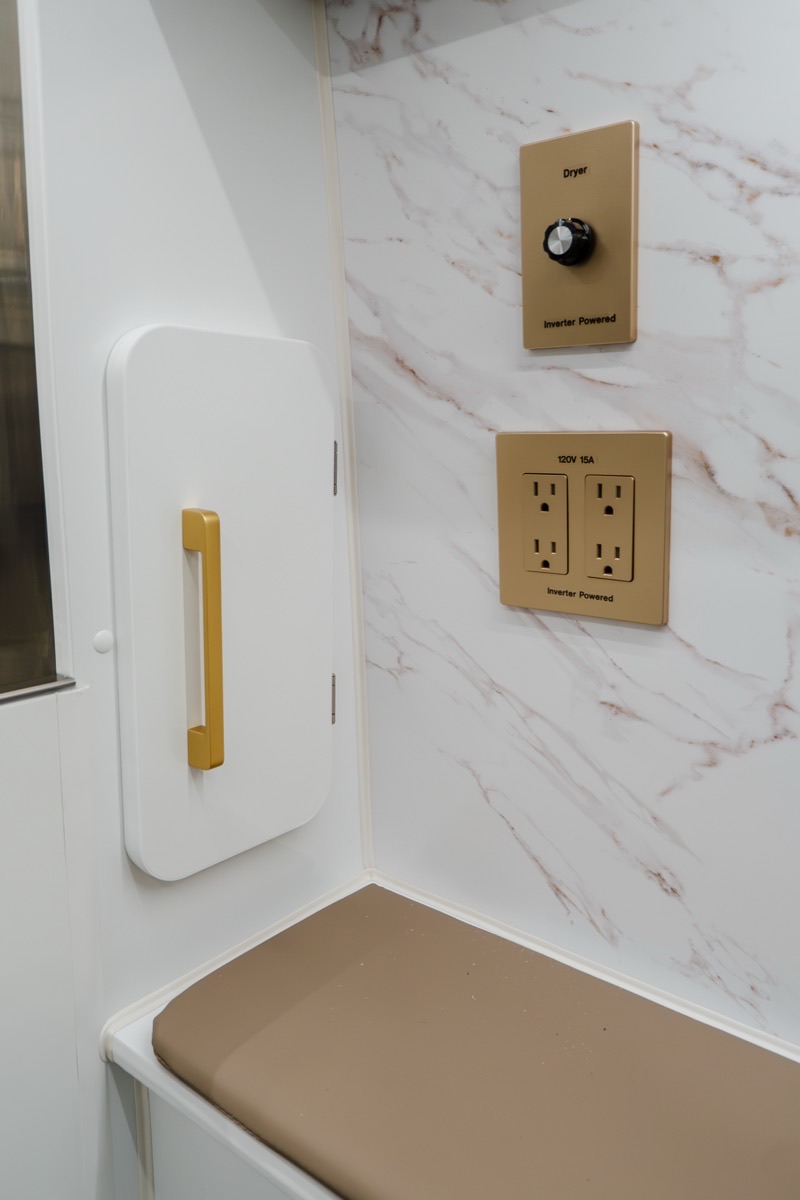 Luxe finish detail with gold dryer controls and marble wall panel