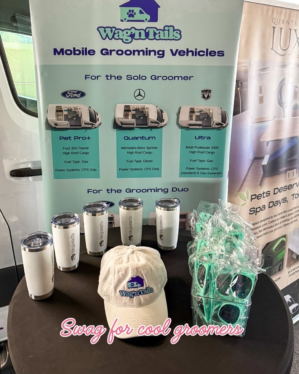 Wag'n Tails booth display with tumblers, hat, and model banners