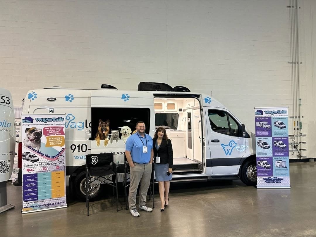 Wag'n Tails booth with a branded mobile grooming van and teammates on the tradeshow floor
