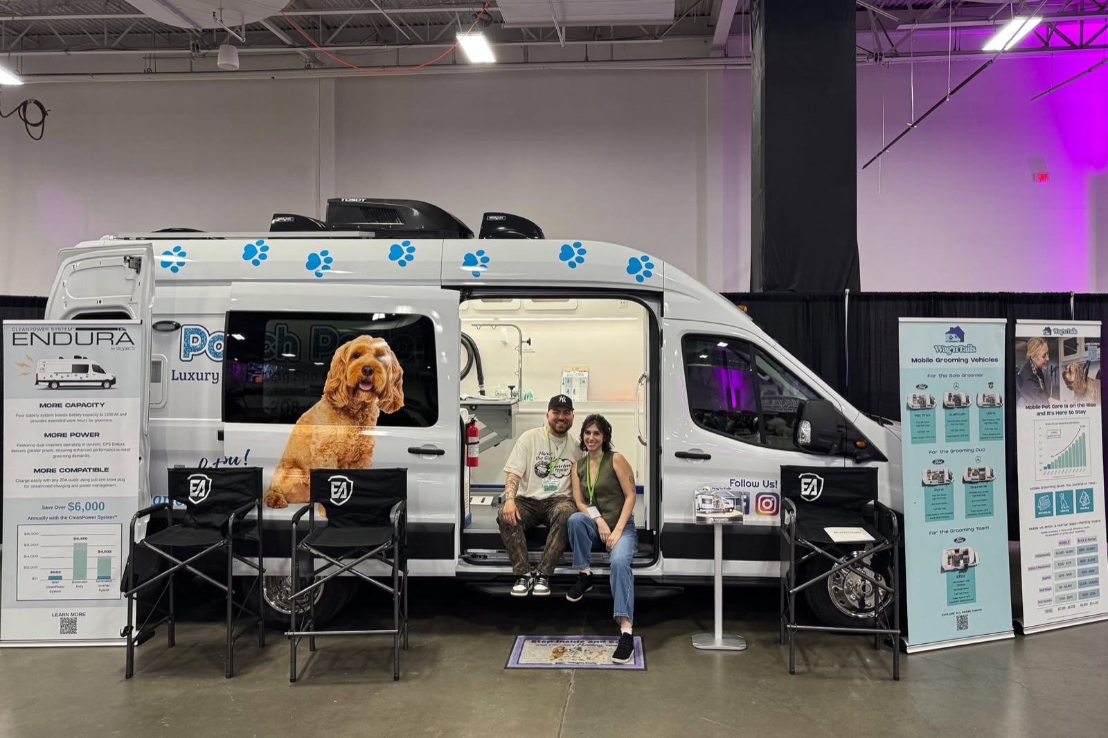 Visitors sitting in a Wag'n Tails mobile grooming van exhibit at a tradeshow