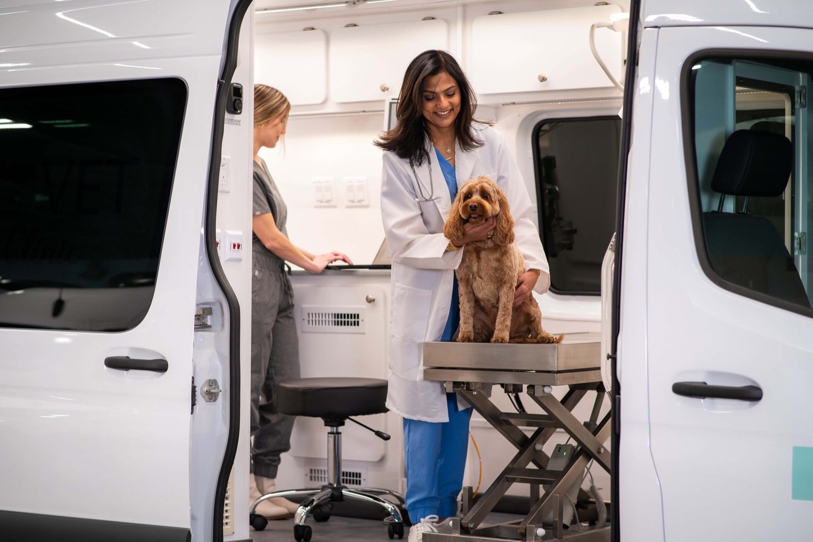 Veterinarian with a dog inside a Wag'n Tails mobile clinic