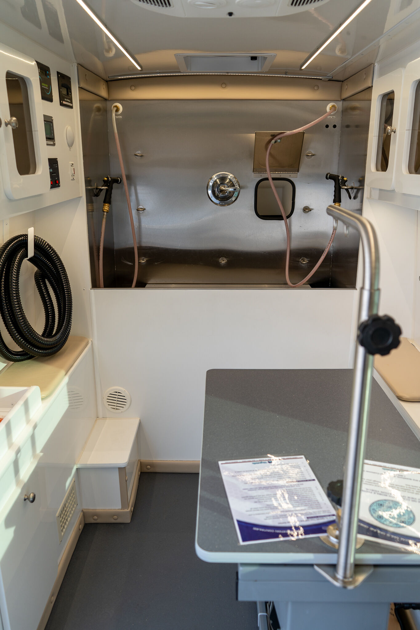 Interior of a compact aircraft medical cabin with stainless steel wall, hoses, and control panels on the left side.