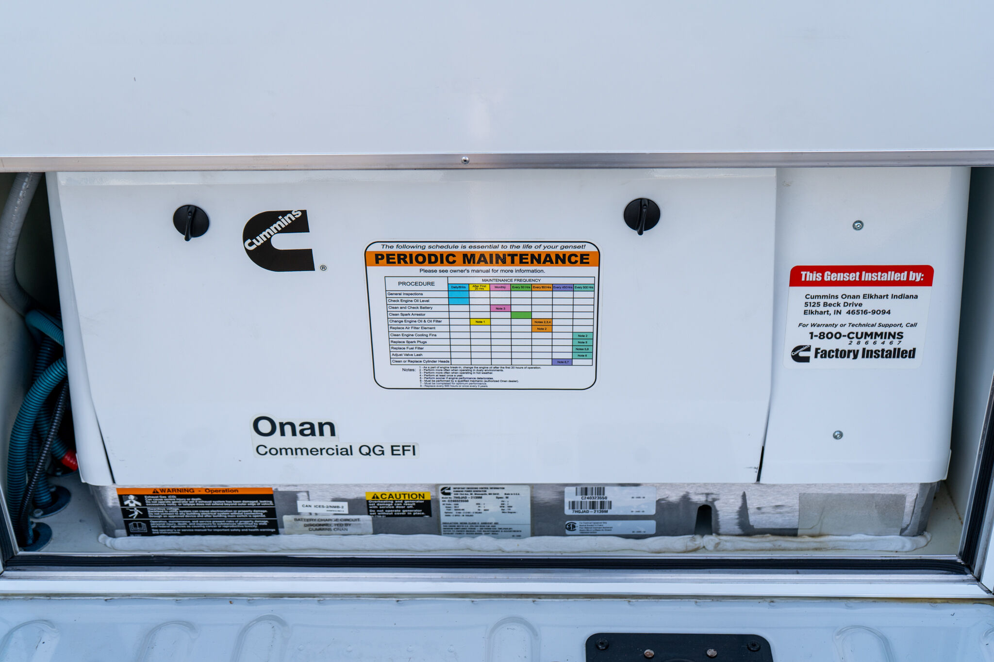 Front panel of a Cummins generator showing a 'Periodic Maintenance' sticker and maintenance chart.